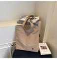 Close-up of beige waterproof tote bag with textured nylon fabric and side logo detail - Khaki