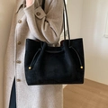 Borsa tote classica in camoscio nero con coulisse e perline dorate mostrata su modella - Nero