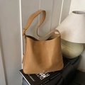 Sac cabas minimaliste en cuir marron avec boucle dorée sur un fauteuil noir chic - Marron