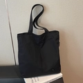 Minimalist black waterproof nylon tote bag with round metal badge and shoulder straps - Black