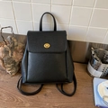 Dettaglio di uno zaino vintage in pelle nera con l'elegante chiusura a scatto dorata - Nero