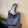 Borsa a tracolla Oxford a quadri blu scuro con tracolla regolabile su divano nero - Blu