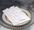 Elegante invito bianco intagliato al laser su piatto dorato con sfondo in lino bianco - Bianco