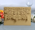 Close-up of champagne gold laser-cut wedding invitation with intricate floral patterns - Beige Gold