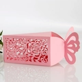 Macro detail of laser-cut rose patterns and butterfly lid on pink wedding candy box - Pink