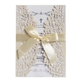 Elegant laser-cut ivory wedding invitation with intricate leaf patterns and a satin bow - Ivory