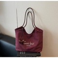 Detalle del bolso tote de ante burdeos con bordado de letras y asas en color marrón - Burdeos