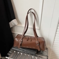 Detalle de bolso bandolera rectangular en cuero marrón oscuro con doble cierre de cremallera - Marrón