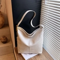 Minimalist beige hobo tote bag in textured faux leather with gold hardware on wooden surface - Off White