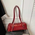 Detalle de bolso de hombro en cuero rojo con hebillas plateadas en fondo vintage - Rojo