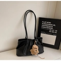 Detail of black leather tote bag with pleated sides and cute brown plush puppy pendant - With Pendant / Black