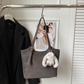 Close-up of vintage dark grey leather tote bag featuring a plush rabbit charm and long strap - Gray (With Charm)
