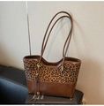 Detalle de bolso tote patchwork de leopardo con elegante colgante de flecos y asa cuero - Estampado de leopardo