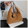 Detail of soft brown leather texture and logo on this large crossbody hobo bag - Brown