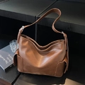 Dark brown leather shoulder bag featuring side flap pockets and adjustable strap - Brown