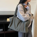 Bolso tote de nailon acolchado verde oliva con cordón, mostrado por una modelo - Gris