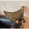 Detail view of olive green quilted nylon half-moon bag with adjustable wide strap - Green