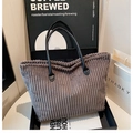 Dettaglio della borsa tote in velluto grigio con trama a righe e manici in pelle nera chic - grigio scuro