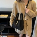 Borsa a secchiello nera opaca retrò con chiusura dorata indossata da una modella - Nero