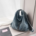 Detail der hellblauen gewaschenen Denim Hobo-Tasche mit verstellbarem Gurt und Metallteilen - Hellblau