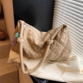 Detail einer beige gesteppten Umhängetasche mit Rautenmuster und dekorativem Seil - Khaki