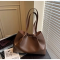 Gros plan du sac cabas en cuir marron sur un bureau avec un livre d'art et PC - café
