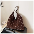 Nahaufnahme der braunen Hobo-Tasche aus Wildleder mit Nieten auf einer Lederbank - Braun