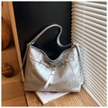 Macro detail of the silver metallic texture and golden metal buckle on the large tote bag - Silver