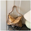 Detail of vintage bronze tote bag with textured finish on Andrew Martin book - Brown