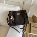 Bolso cubo vintage marrón oscuro con colgante de perro y cierre dorado en sofá - Ébano con Colgante