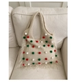 Dettaglio della borsa tote in maglia beige con pompon colorati e lunghe frange ai lati - Bianco