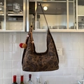 Bruine paisley draagtas met decoratieve pompons en kralen hangend in een huis - Paisley (PANDUOLA-0125)