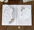 Detail of laser-cut white wedding invitation set with rose pattern on dark wood background - Standard Type / White