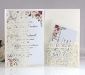 Detailed laser-cut lace wedding invitation with elegant floral insert cards on a stand - Ivory