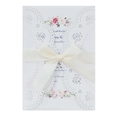 Detail of laser-cut rose hollow wedding invitation with floral insert and cream ribbon bow - White