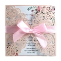 Close-up of laser-cut wedding invitation with pink satin bow and intricate floral lace - Full Set / Light Pink