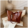 Dettaglio ravvicinato della borsa tote marrone vintage con ciondolo di perline e logo oro - Con Ciondolo / Marrone