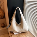 Grande borsa hobo crema con ciondolo a scacchi su un davanzale in legno soleggiato - Bianco con ciondolo