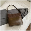 Brown patchwork bucket bag with adjustable strap on white bedding backdrop - Coffee without Pendant