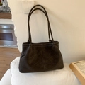 Dark brown matte leather tote bag with white contrast stitching on a minimalist sofa - Coffee without Pendant