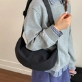 Bolso bandolera de media luna negro minimalista llevado por una modelo para diario - Negro