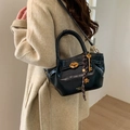 Bolso tipo cubo de cuero negro con costuras blancas y cierre de giro dorado - Negro
