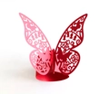 Macro shot of laser-cut red butterfly paper napkin ring with intricate hollow floral patterns - Red