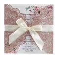 Macro detail of laser cut rose gold glitter wedding invitation with satin bow decoration - Apple Gold