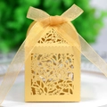 Macro shot of gold laser-cut rose wedding favor box with an organza ribbon bow - Gold