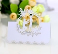 Detail of laser-cut white wedding place card featuring a romantic proposal design - Ivory