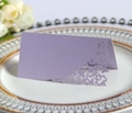 Close-up of lavender laser-cut place card with floral hollow pattern on a white porcelain plate - Light Purple