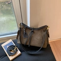 Dettaglio borsa a spalla scamosciata verde oliva con finiture in pelle nera e metallo oro - Verde