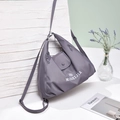 Detail of dark grey-purple versatile nylon tote bag featuring front magnetic flap pocket - Purple