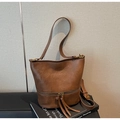 Detail der braunen Vintage-Eimertasche aus Leder mit Reißverschluss und langen Fransen - Braun